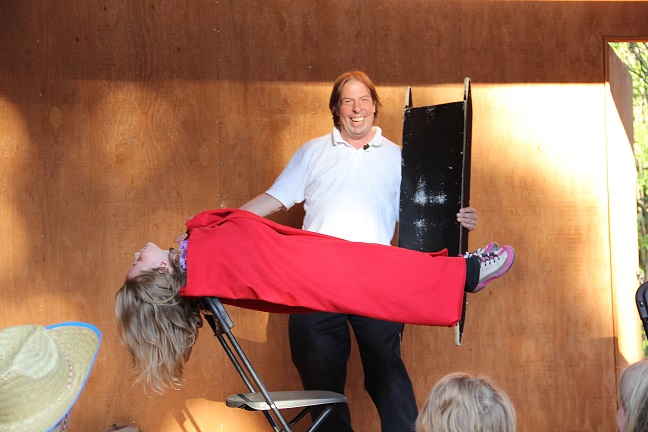 A man performs a magic trick for a girl